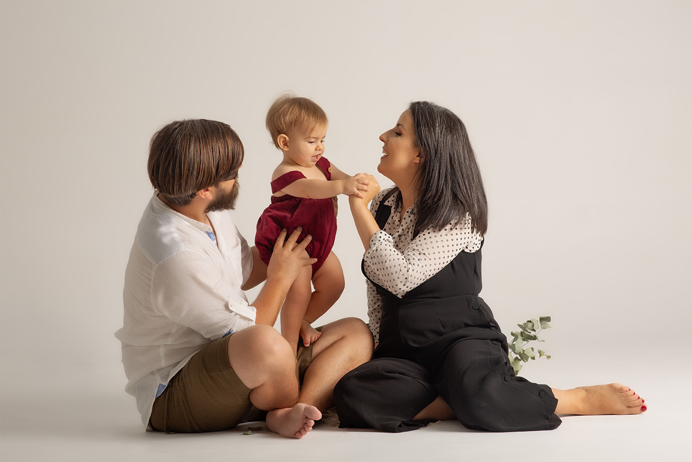 familia de tres, los papas con su bebe en el centro riendo