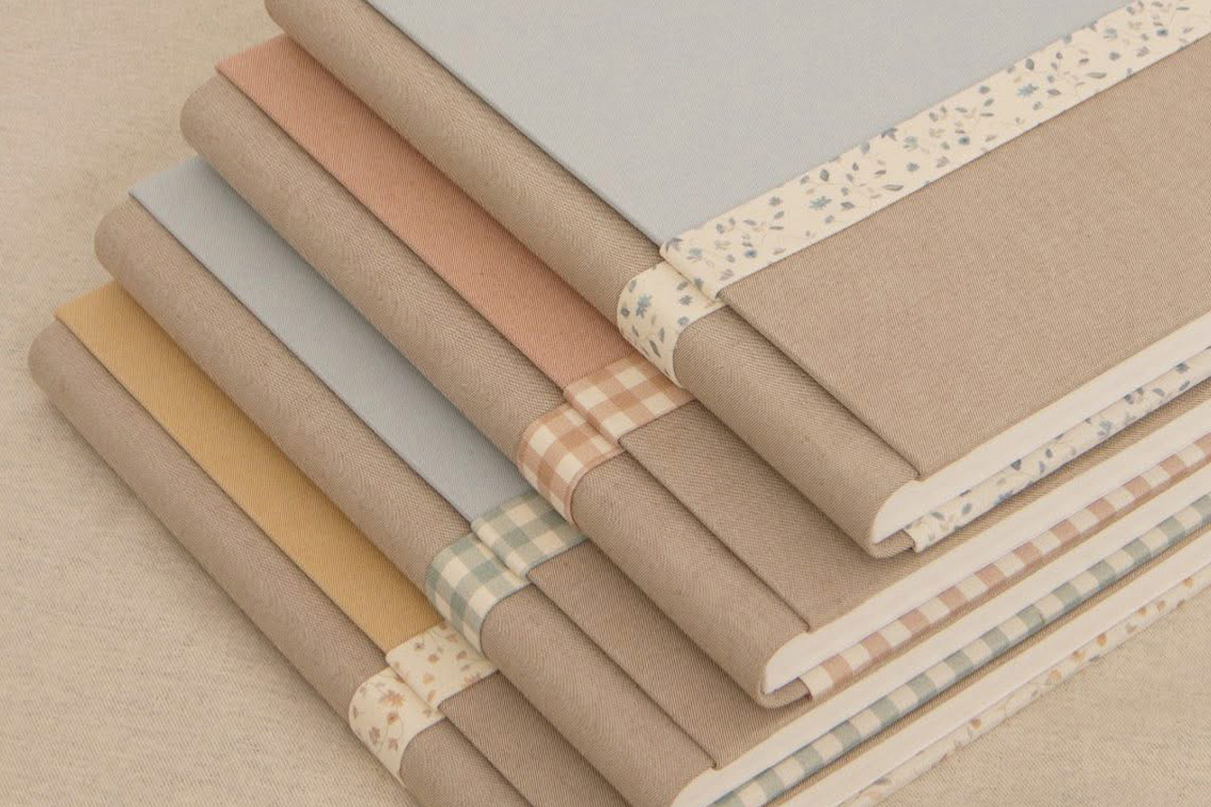 niña pequeña sentada a los pies de un arbol y rodeada de flores