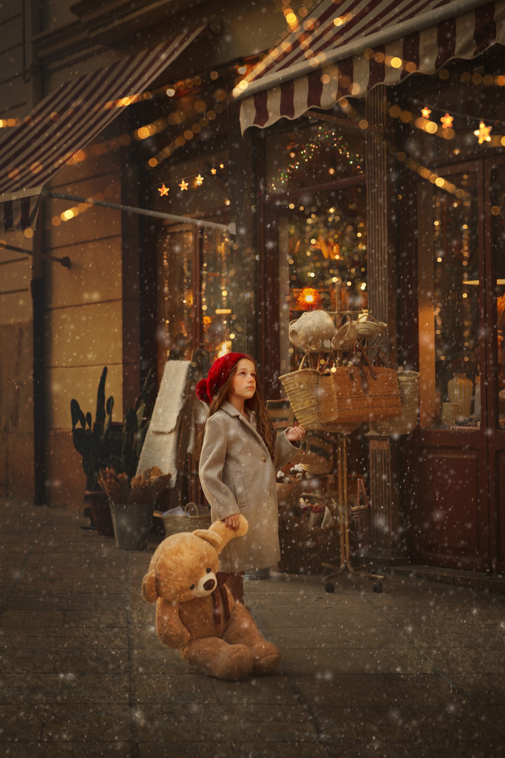 sesion-de-fotos-navidad-en-valencia-para-niños-7 niña en valencia en una foto de navidad con nieve y luces con un oso gigante de peluche