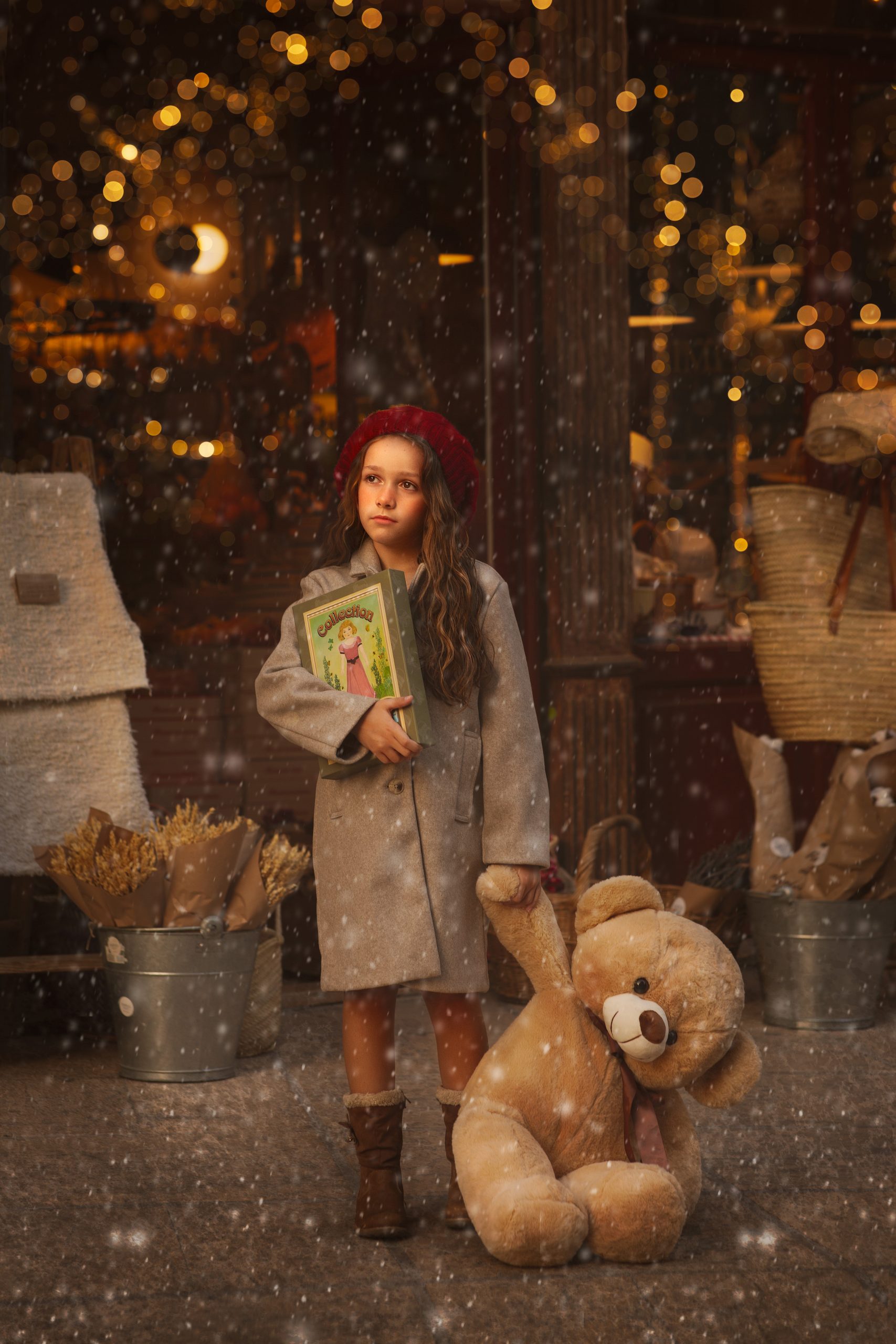 sesion-de-fotos-navidad-en-valencia-para-niños-8 niña en valencia en una foto de navidad con nieve y luces con un oso gigante de peluche