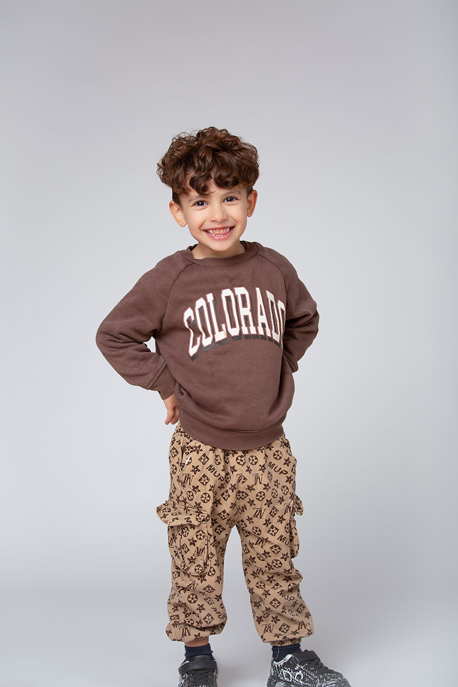 niño modelo infantil posando de forma natural y profesional en una editorial de moda en la calle